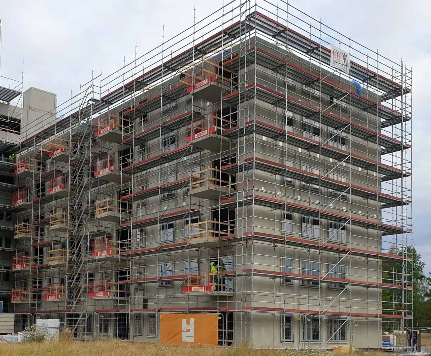 Byggnadsställning monterad på ett flerbostadshus under entreprenad